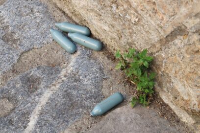 Quatre cartouches de protoxyde d'azote jetées au sol, sur un trottoir. - Agrandir l'image, fenêtre modale