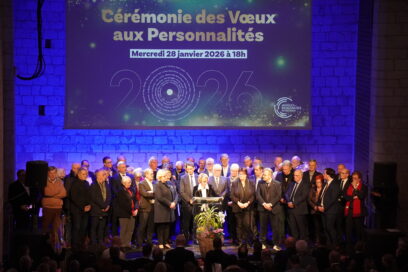 Cette image montre une scène de cérémonie officielle se déroulant dans une salle aux murs de pierre éclairés d'une lumière bleue intense. - Agrandir l'image, fenêtre modale